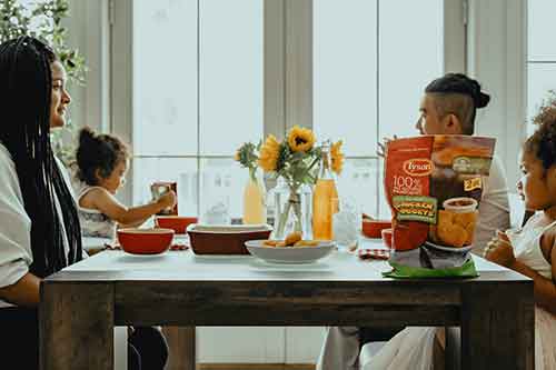 family at table eating food.